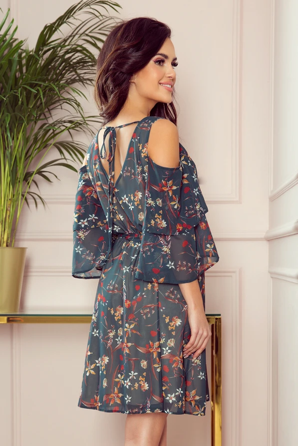 A flowy, floral dress with a cold shoulder design and layered ruffles, perfect for a breezy, elegant look. The dress features a delicate tie at the back, adding a charming detail to its sophisticated style.