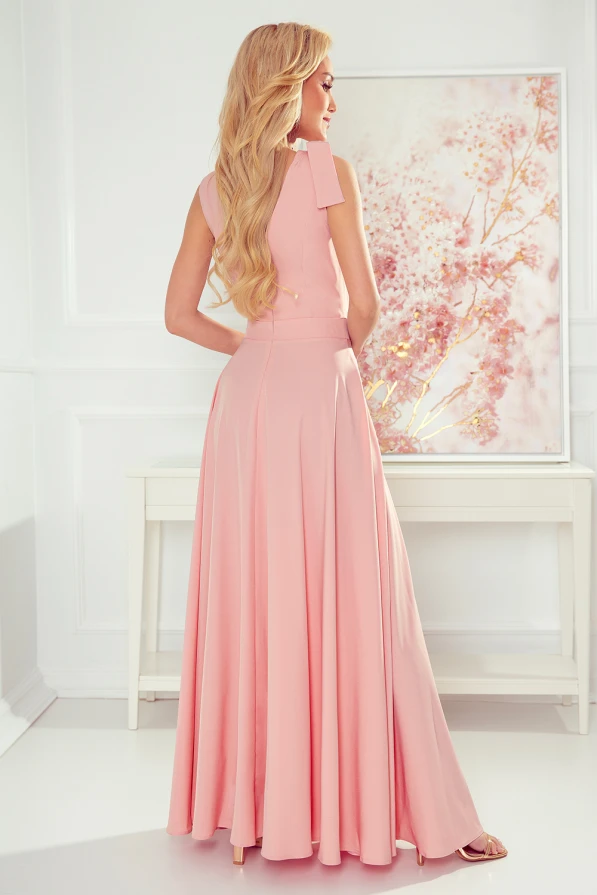 A long, elegant pink dress with a fitted bodice and flowing skirt, perfect for formal occasions. The dress features a sleeveless design with subtle pleats, adding a touch of sophistication.
