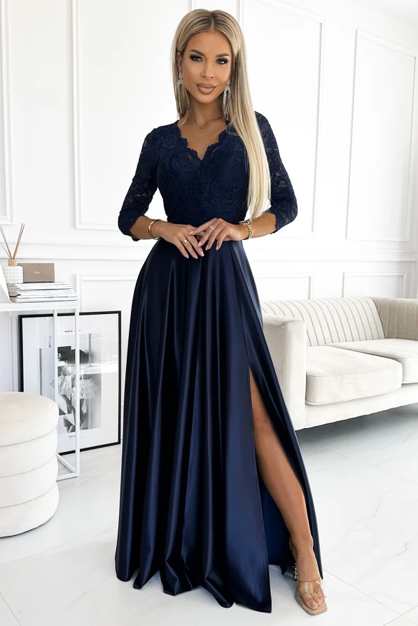 A long, elegant navy blue dress features a lace bodice with three-quarter sleeves and a flowing satin skirt with a high slit. The sophisticated design is perfect for formal occasions, combining classic lace with a modern silhouette.