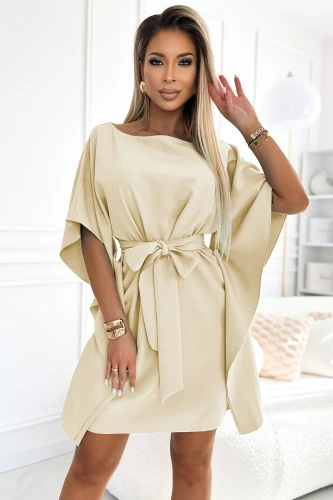 A stylish beige dress with a loose, flowing fit features wide sleeves and a waist-cinching tie belt. The elegant design is complemented by a soft, smooth fabric, perfect for both casual and formal occasions.}