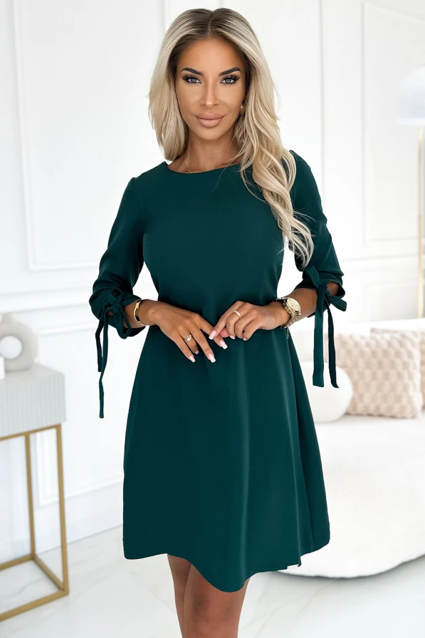 A stylish, dark green trapeze dress with elegant bow-tied sleeves, perfect for both casual and formal occasions. The dress features a simple yet sophisticated design, offering a comfortable and flattering fit.