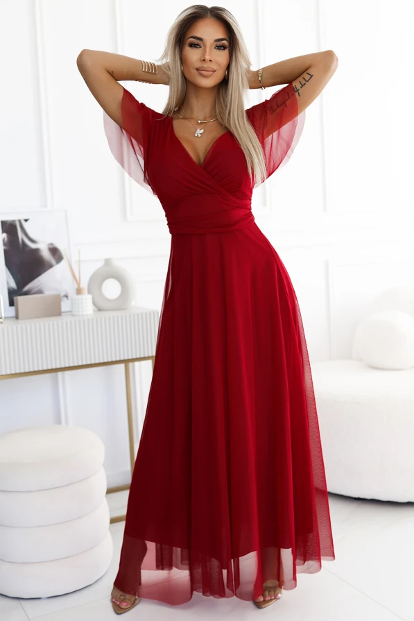 A long, elegant red dress with a fitted bodice and flowing skirt, featuring sheer short sleeves for a sophisticated look. The dress is perfect for formal occasions, offering a blend of classic style and modern design.