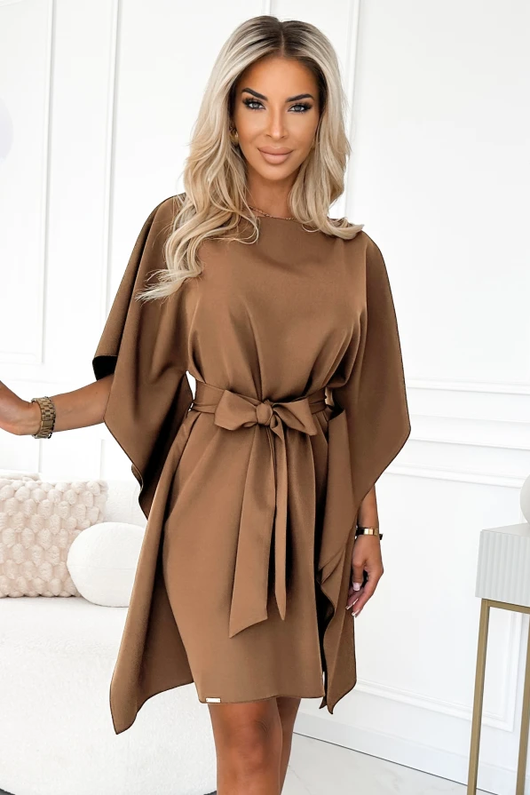 Modelka prezentuje elegancką sukienkę motyl w kolorze karmelowym z wiązaniem w pasie – stylowa propozycja marki Numoco, idealna na jesień.