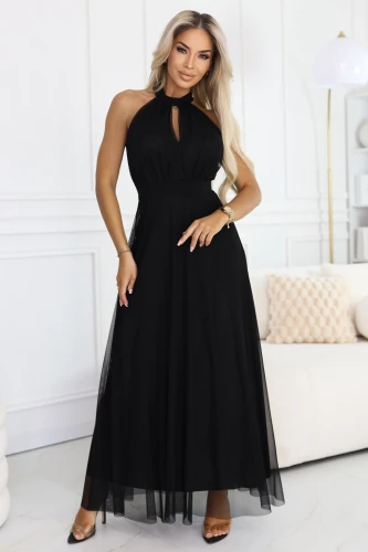 Model in black, long tulle dress with halter neckline and small teardrop cutout, with defined waist and airy, flared bottom.}