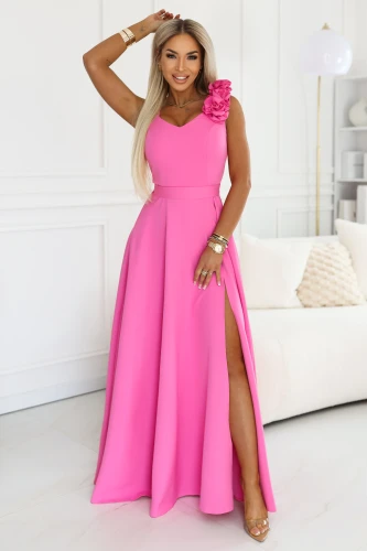 Elegant long women\'s maxi dress in pink, with a leg slit, sweetheart neckline and a decorative flower on the shoulder, Polish production Numoco.}