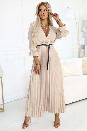 Modelka w beżowej plisowanej sukience maxi z kopertowym dekoltem i paskiem w talii – idealna na wesele, chrzciny, przyjęcia rodzinne, do pracy lub na elegancką kolację.}