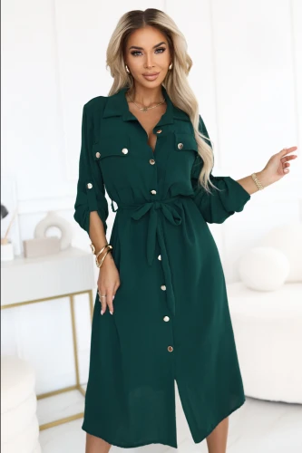 Modelka prezentuje elegancką zieloną sukienkę koszulową midi z możliwością podpięcia rękawów, idealną do pracy i na co dzień.}