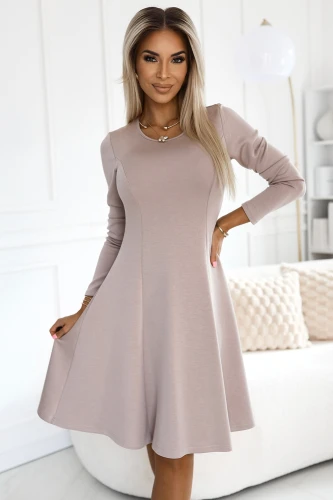 A stylish, trapeze-shaped dress in a soft beige color with long sleeves and a flattering fit. The dress is perfect for both casual and elegant occasions, offering comfort and sophistication.}