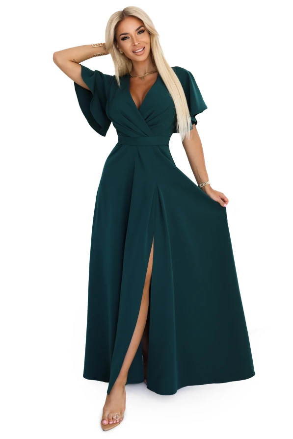 Modelka prezentuje elegancką, długą sukienkę maxi Jennifer marki Numoco w kolorze butelkowej zieleni, z kopertowym dekoltem, luźnymi rękawami i rozcięciem na nodze. Produkt polski, idealny na wyjątkowe okazje.