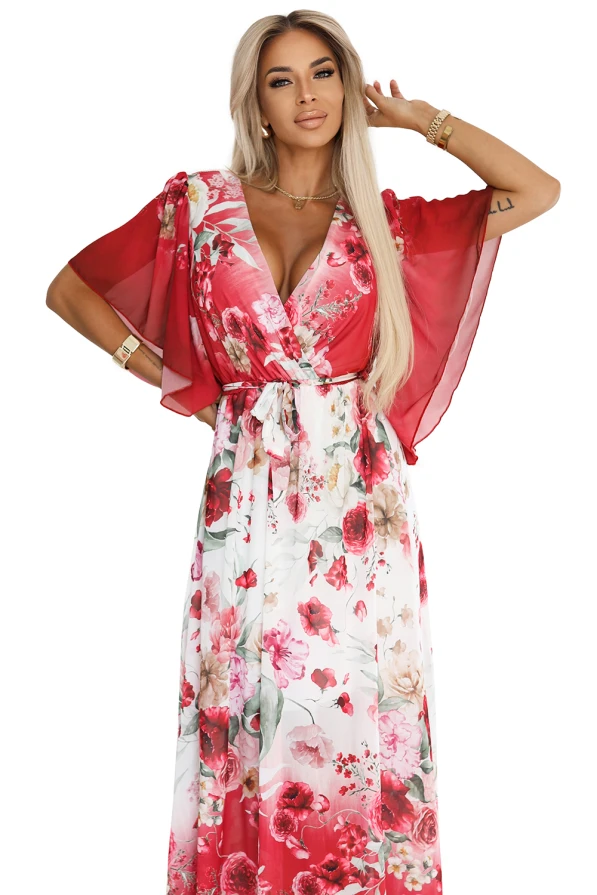 Zwiewna maxi sukienka Numoco z kopertowym dekoltem i szerokimi rękawkami, w kwiecisty wzór z czerwonymi różami, uszyta z lekkiego szyfonu. Modelka prezentuje elegancki, romantyczny fason, który pięknie podkreśla sylwetkę i dodaje kobiecego uroku.